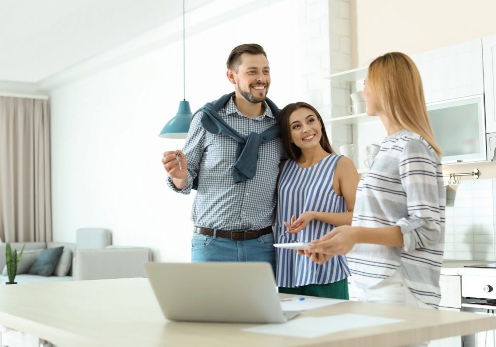 Female,Real,Estate,Agent,Working,With,Couple,,Indoors